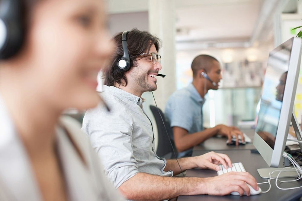 This sales agent appears to be quite happy while talking on his VoIP headset.