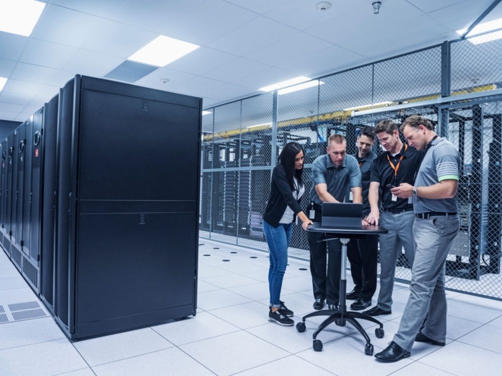 A group of cybersecurity professionals are at the data center making sure their clients' servers are secure.