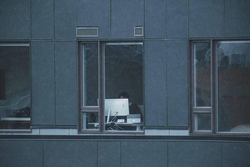 man being watched by hackers through a window