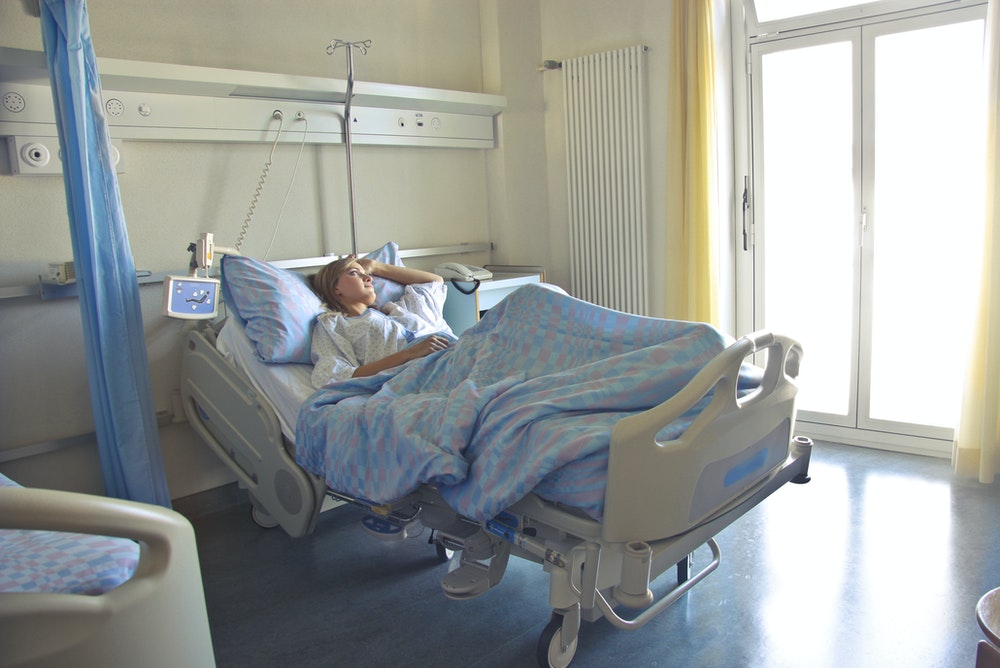 A woman in a hospital bed recovering