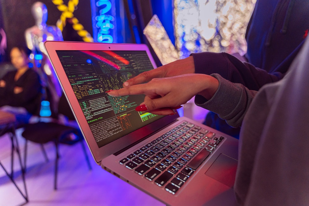 Two people pointing at a laptop