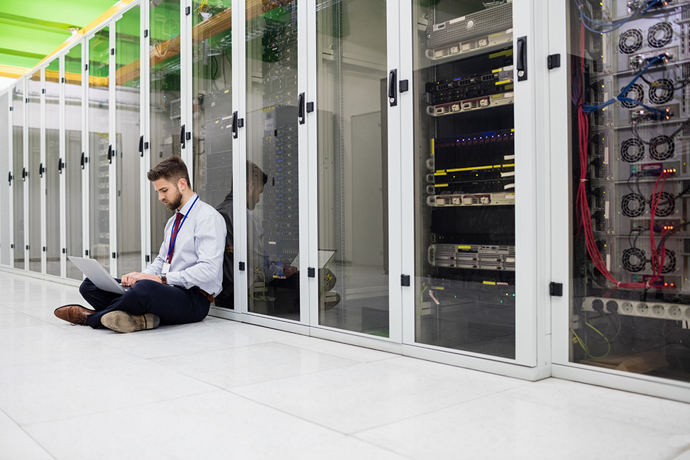 Technician using laptop in server room