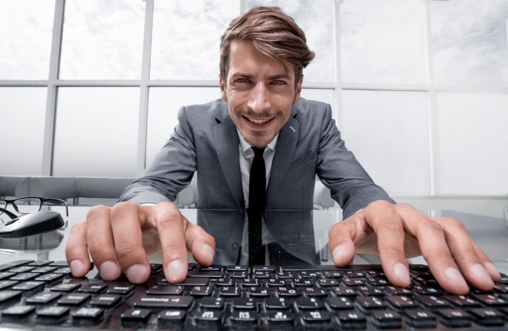 smiling man looking close at the computer screen