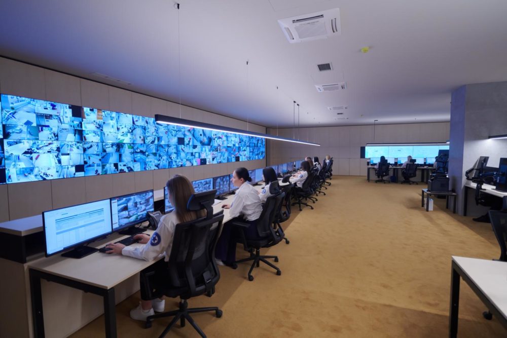 Group of Security data center operators working in a CCTV monitoring room looking on multiple monitors Officers Monitoring Multiple Screens for Suspicious Activities Team working on the System Control Room