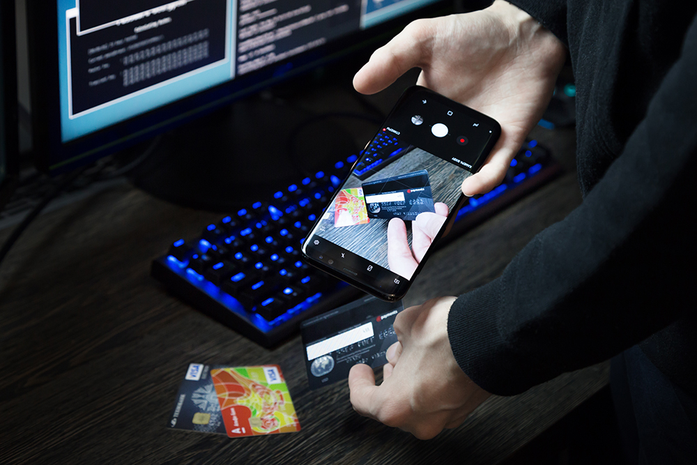 A hacker taking a picture of a credit card