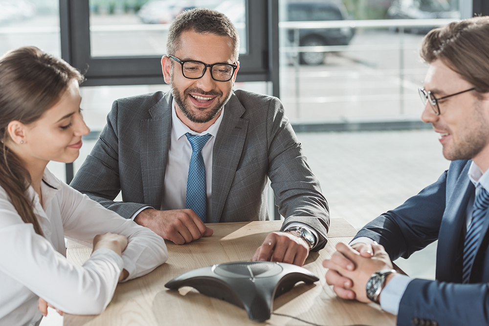 happy business people using conference phone at modern office