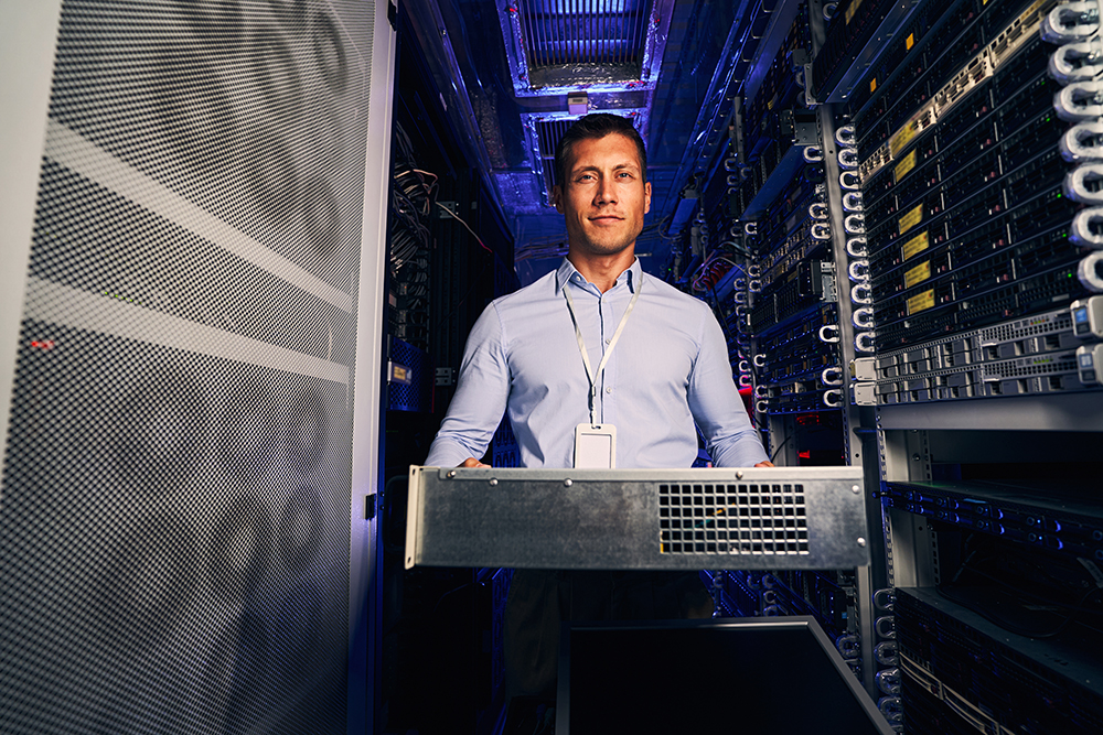 Front view of serene IT technician with rackmount case in his hands looking ahead