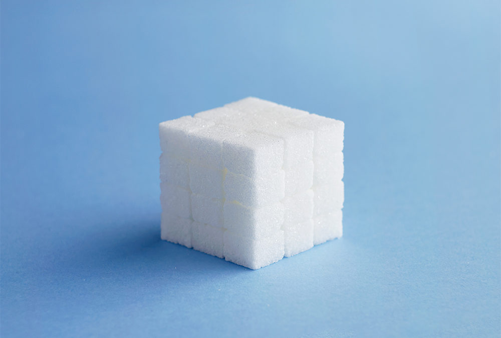 Cube made of sugar cubes over blue background
