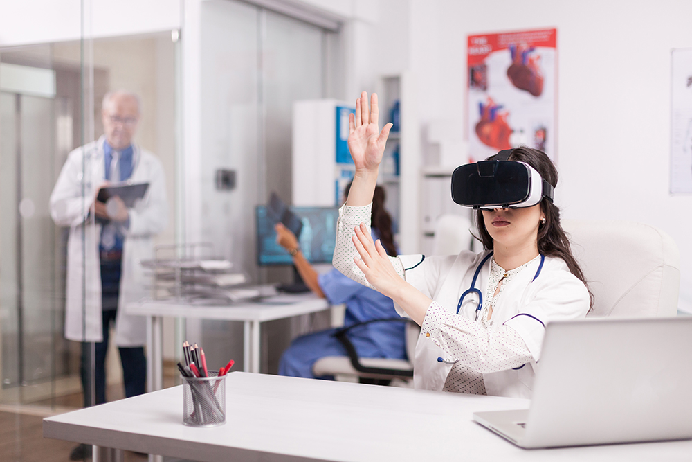 Doctor wearing high tech virtual reality goggles in hospital office and white coat with stethoscope. Senior medical writing patient diagnostic on clipboard and nurse is holding sick man x-ray image.