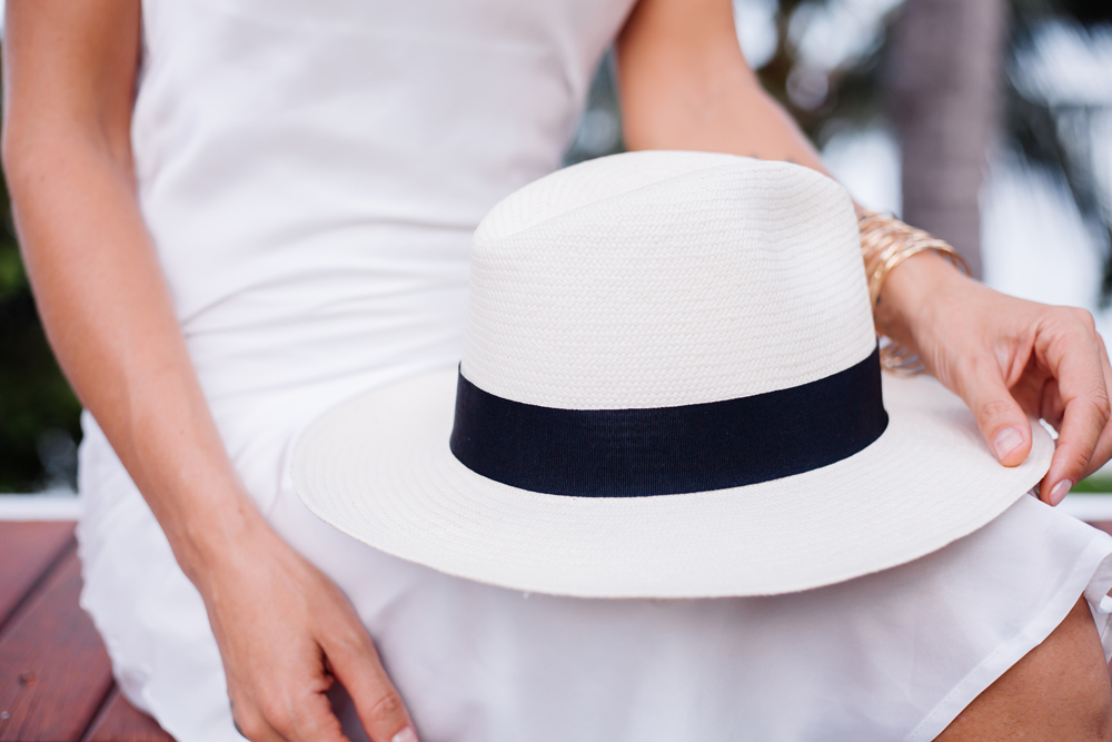 Close shot woman in silk fitting dress with classic white hat