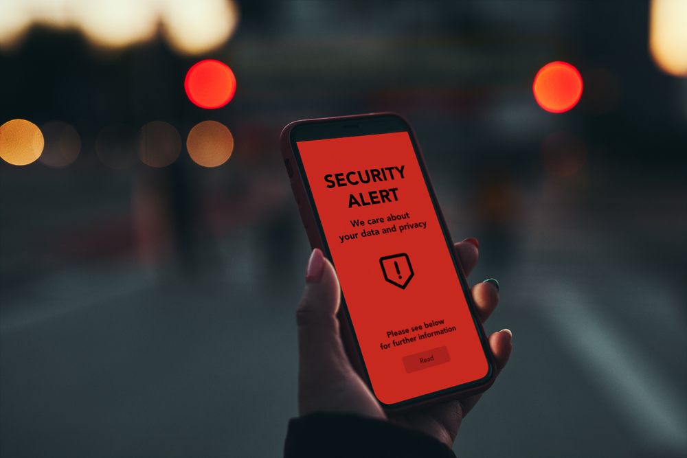 Security alert on smartphone screen. Antivirus warning. Private data protection system notification. Important security issue. Concept of cyber crime, hacking password and bank accounts, stealing money and personal data. Data breach. Female holding mobile phone with displayed security notice