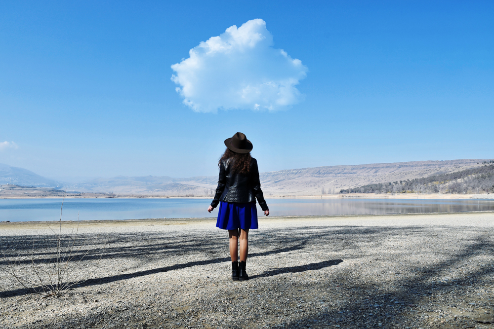 What is cloud cost optimization? Woman walking along a beach under a cloud.