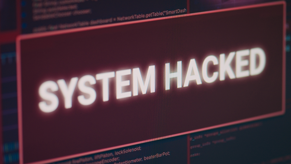 Hacked system alert message flashing on computer screen, showing security breach error and cyber crime attack.