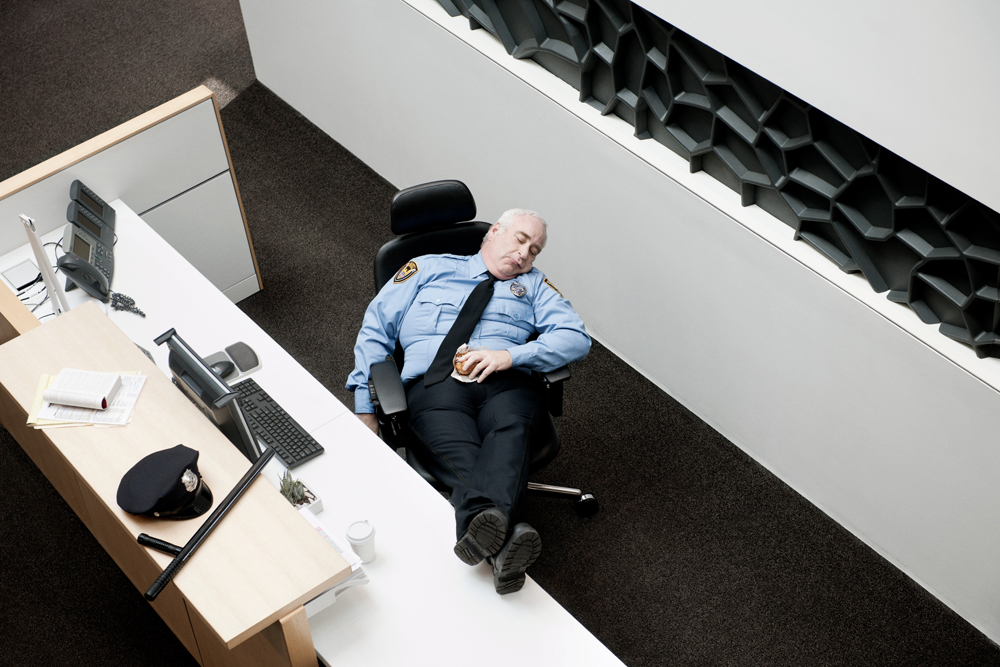 Security guard sleeping on the job at his desk