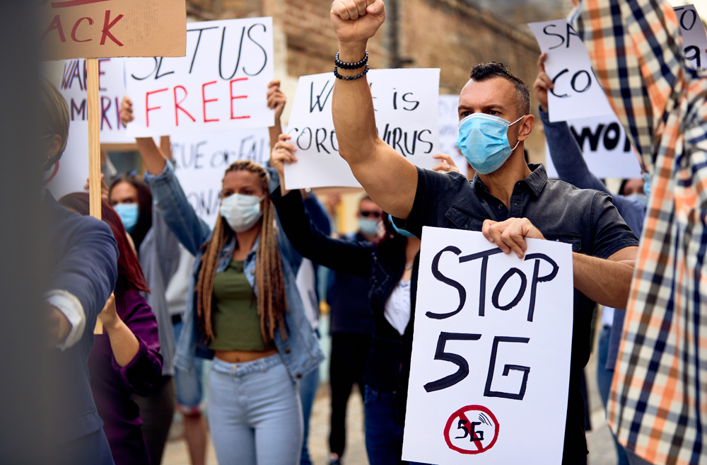 People at a 5G protest holding signs that could lead to 5G attacks
