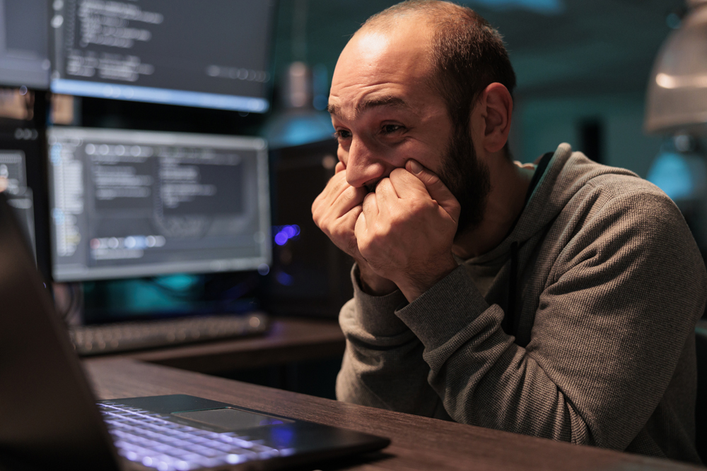 Software engineer looking nervous while updating his computer