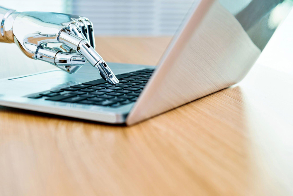 Chatbot robot arm typing on a laptop keyboard