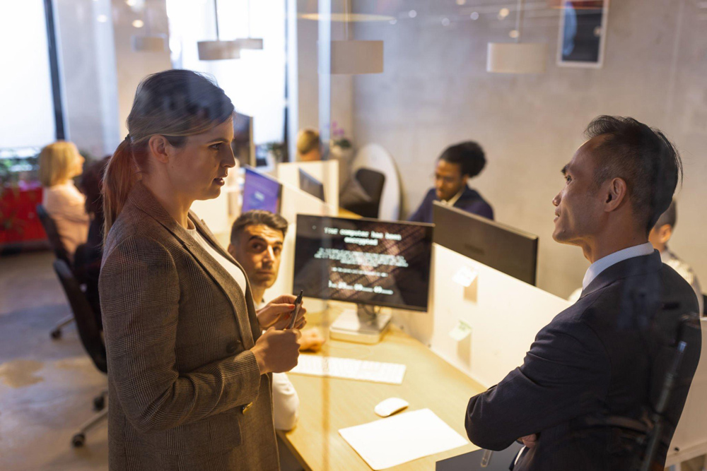 Two C suite employees talking about cybersecurity in a conference room