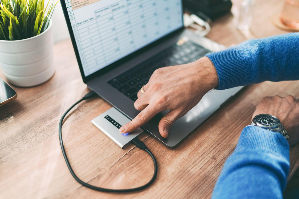 Man unlocking his external hard drive using his fingerprint